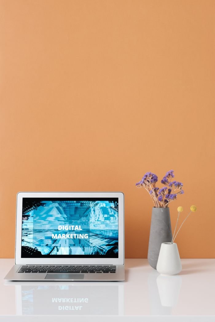 Home Modern workspace with laptop and decorative flowers showcasing digital marketing.